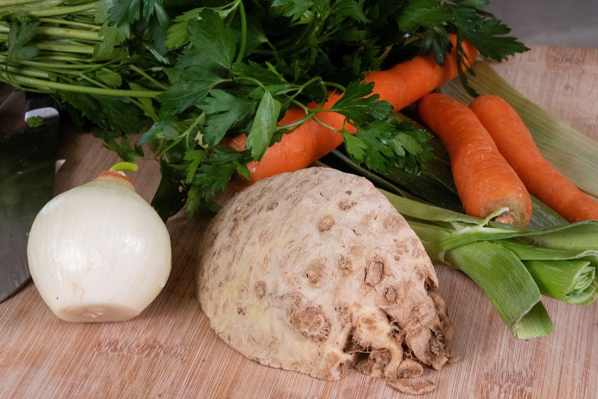 Als Zutaten für die Gemüsebrühe ohne Kochen braucht es Sellerie, Karotten, Zwiebel, Lauch und Petersilie. Wer mag, kann auch noch Liebstöckel verwenden.