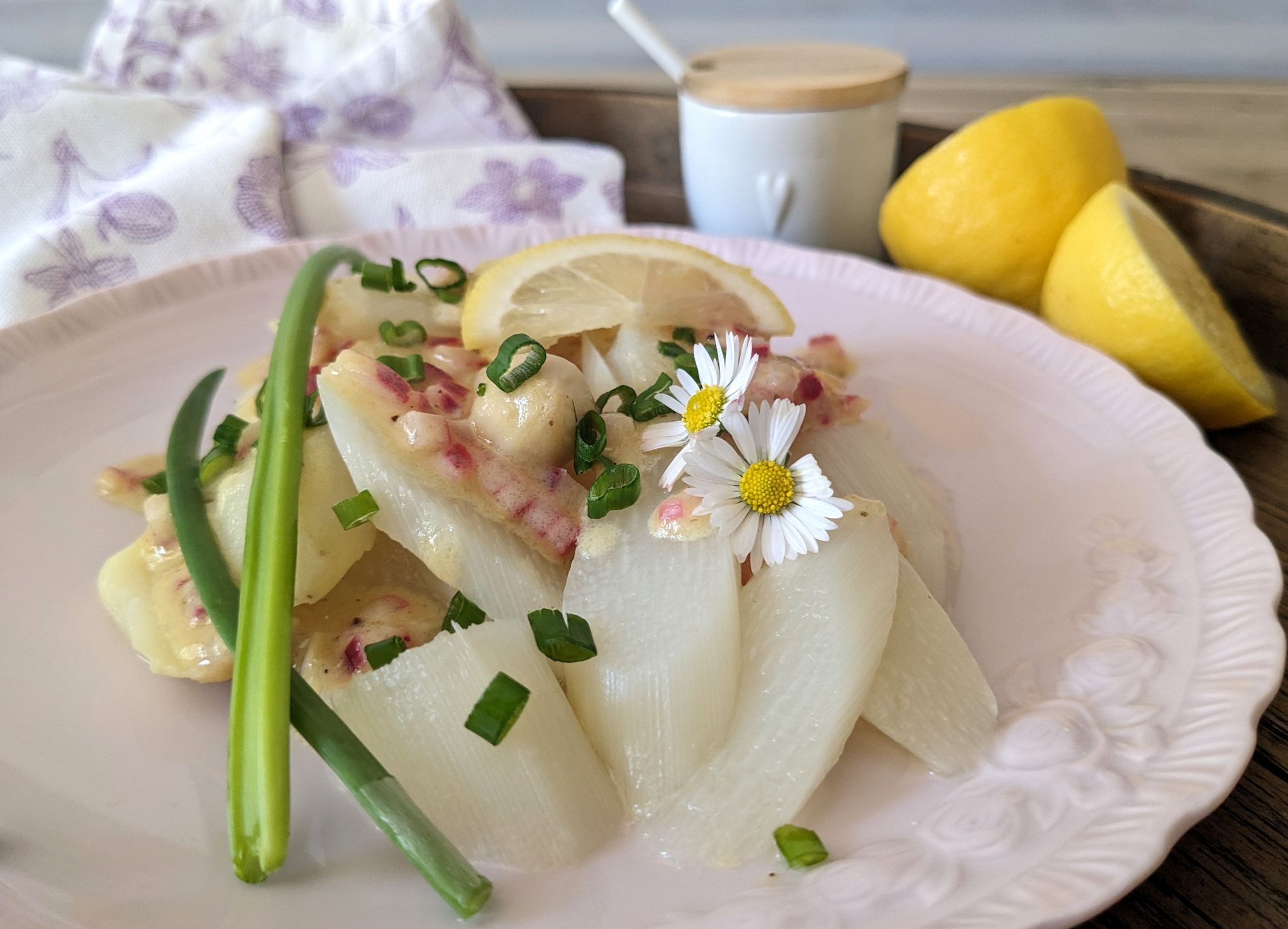 Rote Zwiebelwürfelchen und Gänseblümchen verpassen dem Spargelsalat mit erfrischender Zitrusnote ein paar frühsommerliche Farbtupfer.